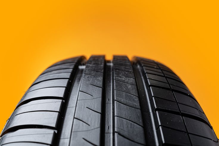 Car tires isolated on yellow background, close up photo